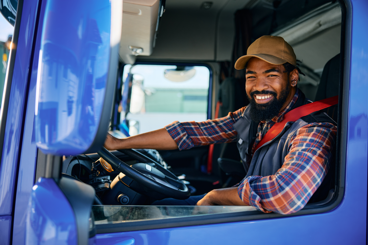 A trucker sits in his big rig cab.